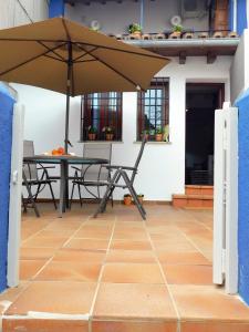 patio ze stołem i parasolem w obiekcie Alborada Apartamentos Rurales w mieście Hervás