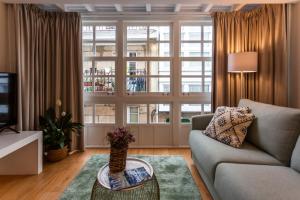 een woonkamer met een bank en een groot raam bij APARTAMENTOS FRANJA 55 in A Coruña