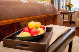 a bowl of apples sitting on top of a bed at Hillcrest Farm Market B&B in Kelowna