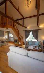 a living room with a couch and a staircase at Cherry Orchard Lodge in Bath