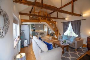 uma sala de estar com mobiliário branco e tectos em madeira em Cherry Orchard Lodge em Bath