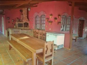 a kitchen with a wooden table and a red wall at Casa do Bosque, 367 in Rio das Ostras