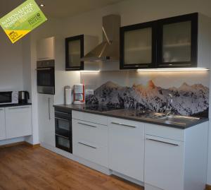 a kitchen with white cabinets and a counter top at Appartement Wieshof in Neukirchen am Großvenediger