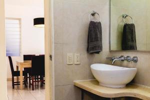 a bathroom with a sink and a mirror and a table at Minerva Apartments in Guadalajara