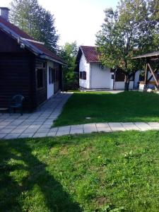 a yard with a house and a patio with a lawn at Ranch Farm Stay in Rakovica