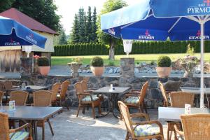 un restaurante con mesas, sillas y sombrilla en Hotel-Burghagen en Langelsheim