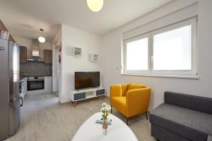 - un salon avec un canapé et une télévision dans l'établissement City Apartment Magdalena, à Trogir