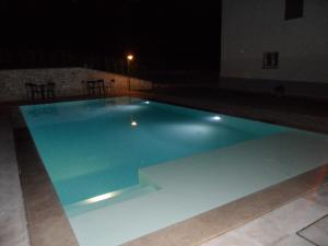 a large blue swimming pool at night at B&B La Madonnina in Montefalco