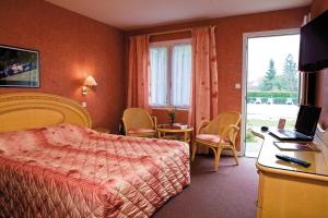 een hotelkamer met een bed en een bureau met een laptop bij Logis Hôtel du Pont Neuf in Le Veurdre