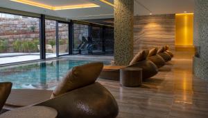 a hotel lobby with a swimming pool and chairs at Vila Foz Hotel & SPA - member of Design Hotels in Porto