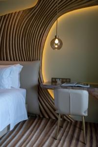 a bedroom with a bed and a desk at Vila Foz Hotel & SPA - member of Design Hotels in Porto