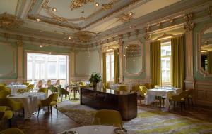 a dining room with tables and chairs and a ceiling at Vila Foz Hotel & SPA - member of Design Hotels in Porto
