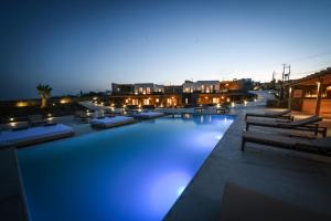 a large swimming pool on a building at night at Myconian Crown Suites in Kalafatis