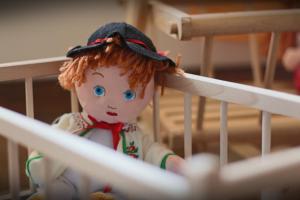 een pop zit in een wieg bij Grand Podhale Resort&Spa Zakopane - Jacuzzi - Sauna fińska i Łaźnia parowa - Widok na Tatry in Zakopane