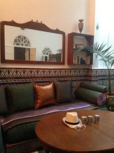 uma sala de estar com um sofá com um chapéu sobre uma mesa em Dar Nakhla Naciria em Tânger