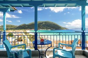 a balcony with a table and chairs and a view of the ocean at Wild Seagull in Vasiliki