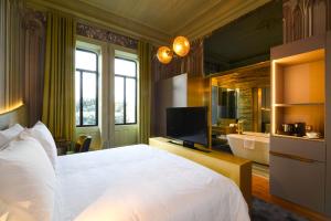a bedroom with a large bed and a bathroom at Vila Foz Hotel & SPA - member of Design Hotels in Porto