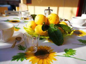 a pile of lemons sitting on top of a table at Maison Etoile de Mer in Agnone Bagni +22 photos