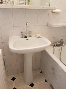 bagno con lavandino bianco e vasca di The Residency a Varsavia