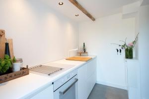 a white kitchen with a white counter top at Studio Haarlemenmeer in Cruquius