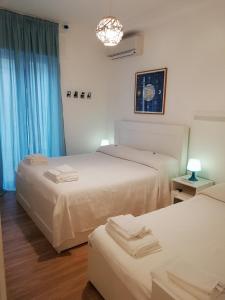 two beds in a room with blue curtains at Blue Sea Apartment in Torre Canne