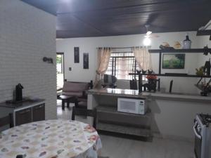 een keuken en een woonkamer met een tafel bij CASA ESPAÇOSA 4 DORMITÓRIOS A 150M DA PRAIA DA MARANDUBA / UBATUBA in Ubatuba +19 foto's