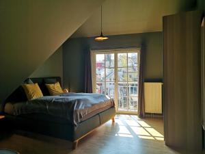 a bedroom with a bed and a large window at Susas Charming Places in Gmunden