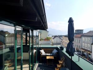 a balcony with an umbrella and a table and chairs at Susas Charming Places in Gmunden