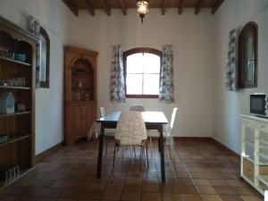 a dining room with a table and chairs and a window at le bien l'authie in Colline-Beaumont