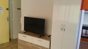 a flat screen tv sitting on top of a dresser at le petit coin de paradis in Sainte-Anne