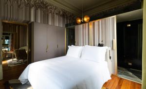 a bedroom with a large bed with white sheets at Vila Foz Hotel & SPA - member of Design Hotels in Porto
