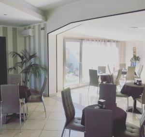 a dining room with chairs and tables and a large window at B&B Ramses in Uta