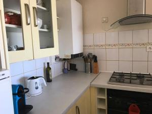 uma cozinha com armários brancos e um forno com placa de fogão em Goelands em Palavas-les-Flots
