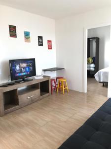 a living room with a flat screen tv sitting on a entertainment center at Pousada Tchê Aprochega in Pelotas