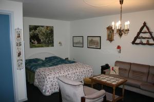 a bedroom with a bed and a couch and a table at Bed and Breakfast Nustrup in Vojens