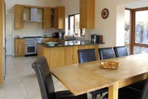 een keuken met een houten eettafel en stoelen bij Westport, Co. Mayo - Sleeps 10, Pool Table, ideal holiday base in Westport