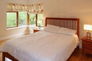 1 dormitorio con 1 cama blanca y 2 ventanas en Westport, Co. Mayo - Sleeps 10, Pool Table, ideal holiday base en Westport