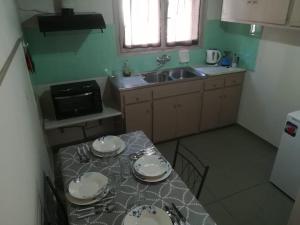a small kitchen with a table with plates on it at Spiti Kritikos in Benitses