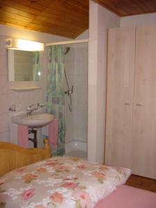 a bathroom with a bed and a sink and a shower at albergovalbella in Rossa