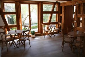 una habitación con mesas, sillas y ventanas en Waldvogel Ferienzimmer klimatisiert, en Immenstaad am Bodensee