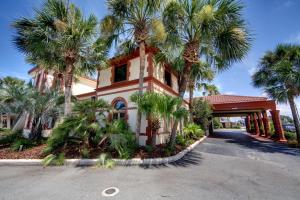 een gebouw met palmbomen voor een straat bij The Flagler Inn - Saint Augustine in St. Augustine