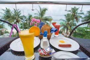 a table with plates of food and a glass of juice at Hotel UI Inn in Hulhumale