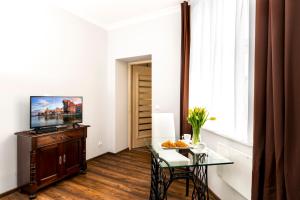 sala de estar con mesa y TV en Apartament Łagiewniki, en Gdansk