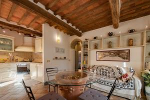 een keuken met een glazen tafel en stoelen bij La Casina di Pia in Montieri