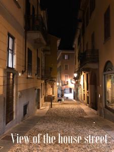 una calle de la ciudad por la noche con vistas al título de la calle de la casa en La Via degli Artisti, en Arona