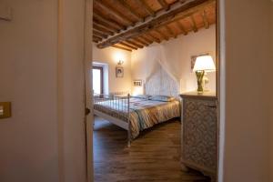 een slaapkamer met een bed en een tafel met een lamp bij La Casina di Pia in Montieri