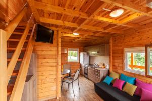 Cabaña de madera con cocina y sala de estar. en Domki Sielanka en Niechorze