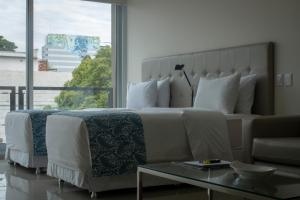a bedroom with a large bed and a large window at START Villa Morra Rent Apartments in Asunción +95 photos