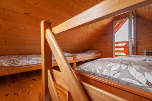 sypialnia z 2 łóżkami piętrowymi w drewnianym domku w obiekcie Domki Sielanka w mieście Niechorze
