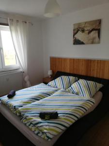 uma cama com um edredão listrado num quarto em Ferienwohnung Waldeck am Edersee em Waldeck